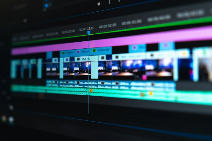 A video editing timeline with blue and purple clips on a dark screen